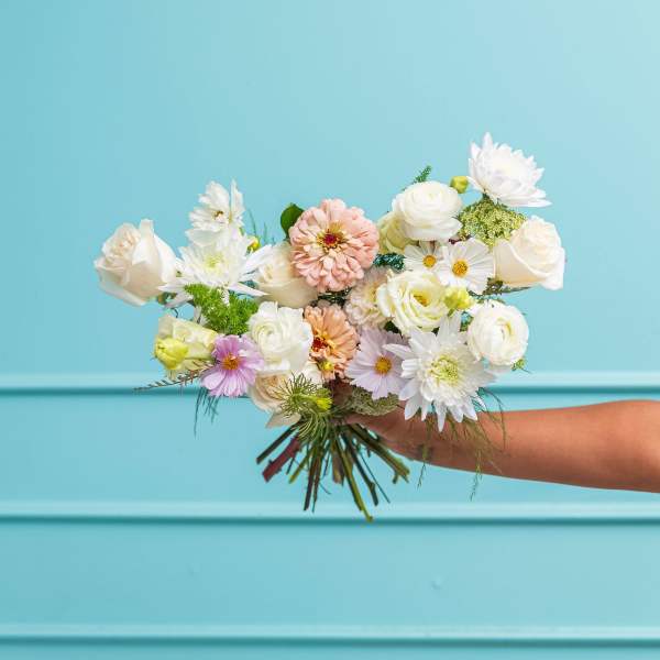 Handheld bouquet of white and pastel flowers