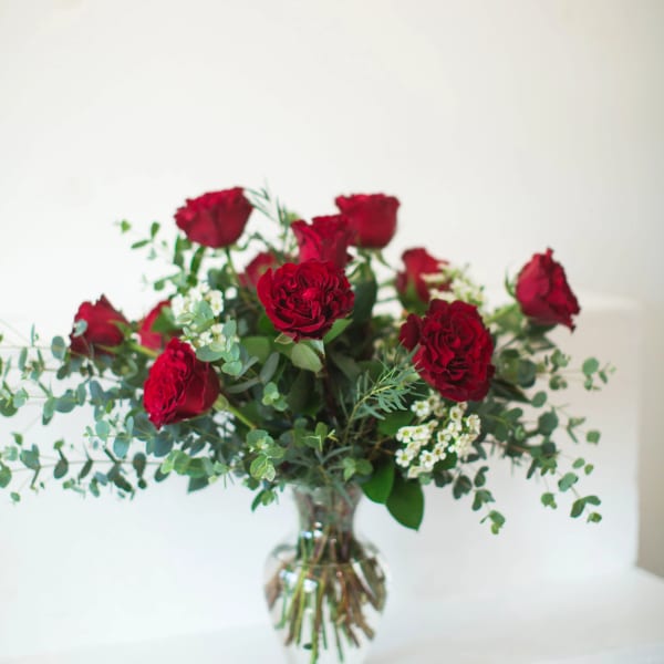 Red roses arranged in a clear glass vase