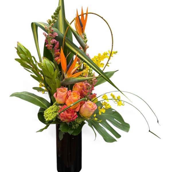 Tropical flower arrangement in a tall black vase with orange blooms and yellow accents