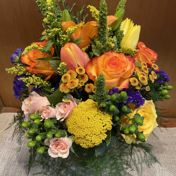Bright mixed bouquet with orange and yellow roses and pink blooms