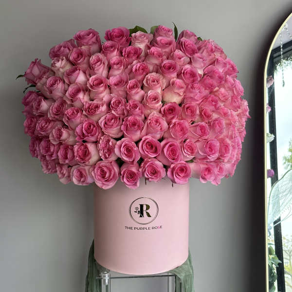 Large dome of bright pink roses arranged in a light pink round hat box.