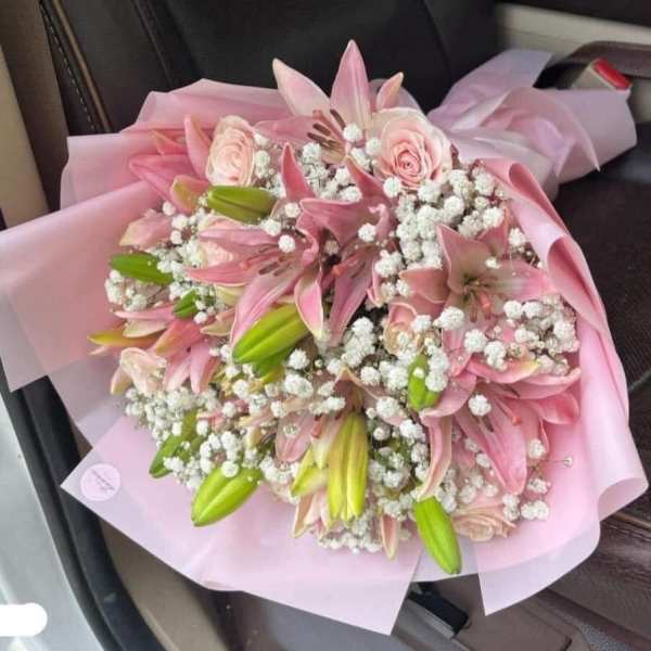 Pink lily and rose bouquet wrapped in pale pink paper
