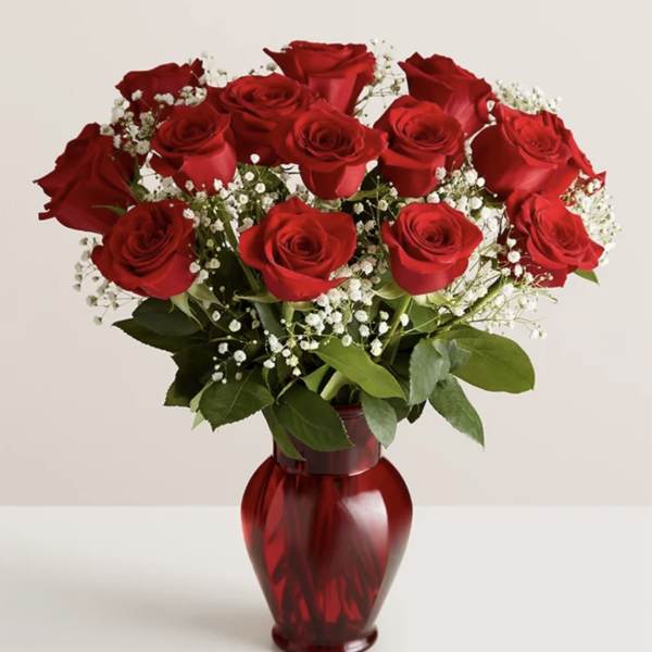 Bouquet of red roses in a red glass vase