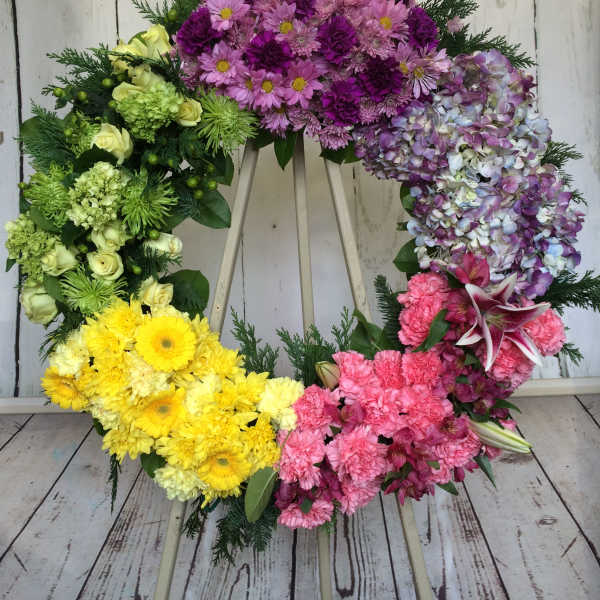 Colorful floral wreath with pink, purple, yellow, and green blooms