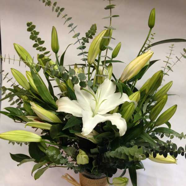 White lily bouquet in a burlap-wrapped vase