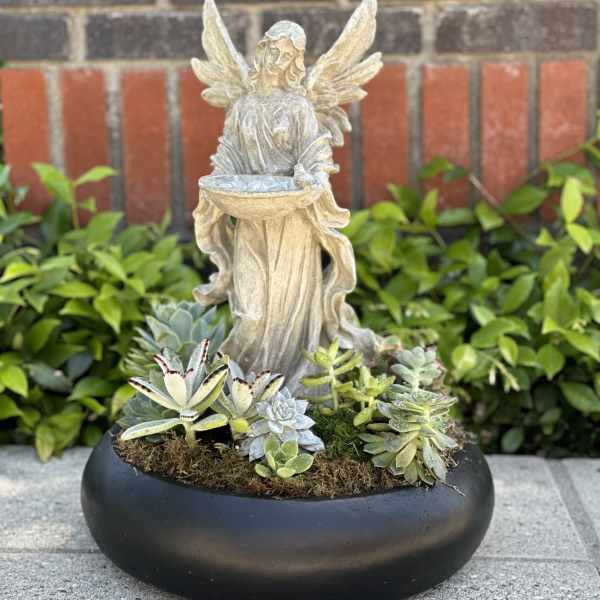 Succulent planter with an angel statue in a black bowl container