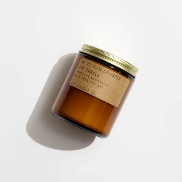 Amber jar candle with a gold lid and paper label