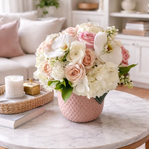 Pink and white flower arrangement in a textured pink vase