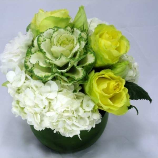 Green and white floral arrangement in a dark green vase
