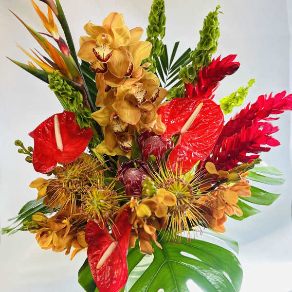 Tropical bouquet with red anthuriums, yellow orchids, and bird-of-paradise