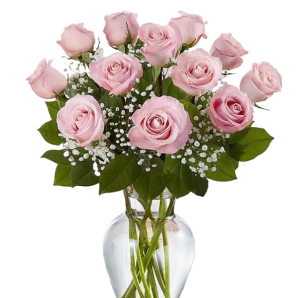 Pink roses arranged in a clear glass vase with baby's breath