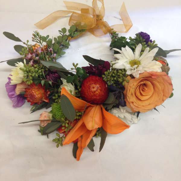 Colorful floral wreath with orange ribbon and mixed blooms