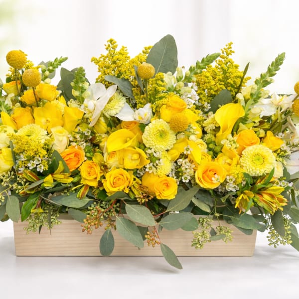 Yellow floral arrangement in a rectangular wooden box