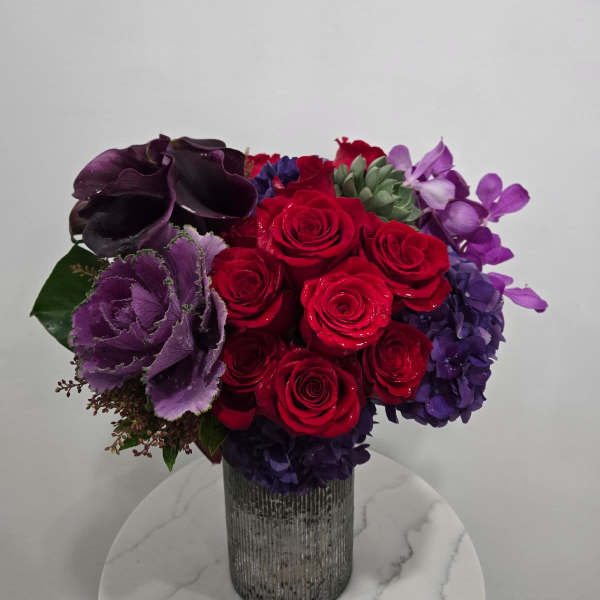 Red and purple rose arrangement in a silver vase