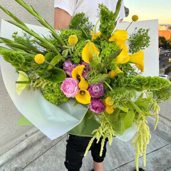 Large bouquet with yellow calla lilies, pink ranunculus, and green blooms