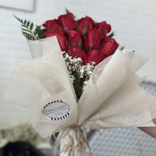Bouquet of red roses wrapped in cream paper