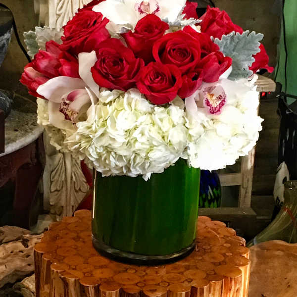 Red roses and white orchids arranged in a green vase