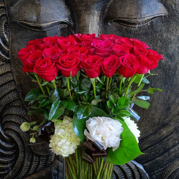 Red roses and white blooms arranged in a clear glass vase