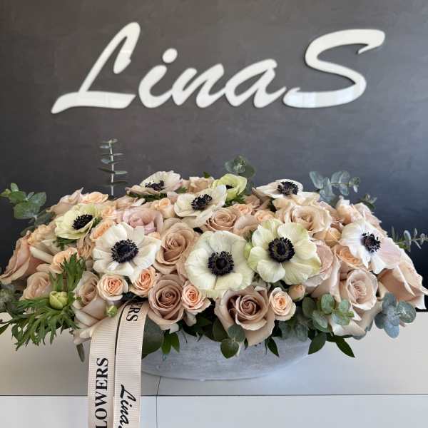 Blush rose arrangement with white anemones in a low oval container