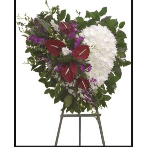 Heart-shaped funeral spray with white and burgundy flowers on an easel