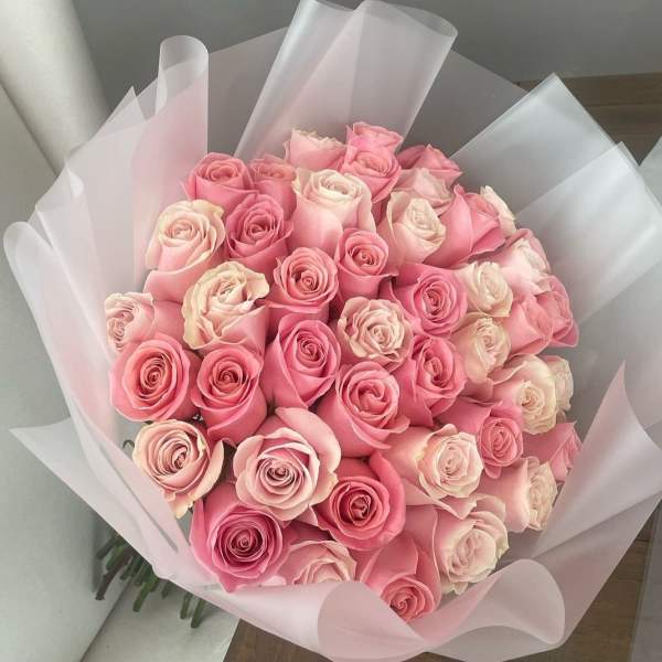 Bouquet of pink and blush roses wrapped in pale pink paper