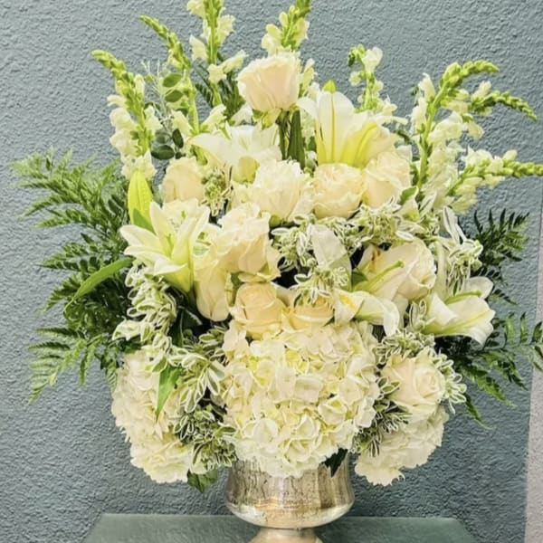 Creamy white floral arrangement in a silver vase