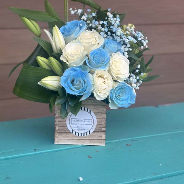 Blue and white roses with lily buds in a wooden box