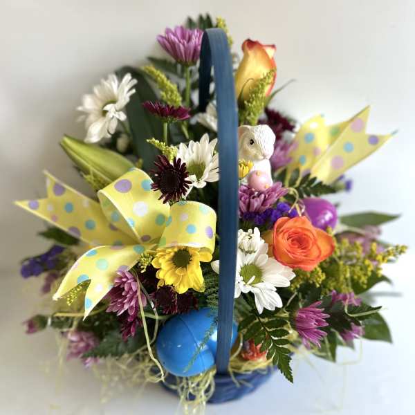 Colorful flower basket with daisies, roses, and a small bunny figurine