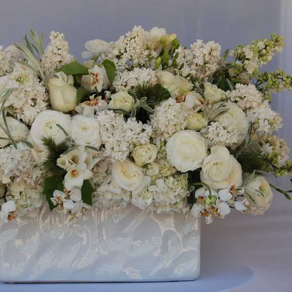 White floral arrangement in a glossy rectangular vase