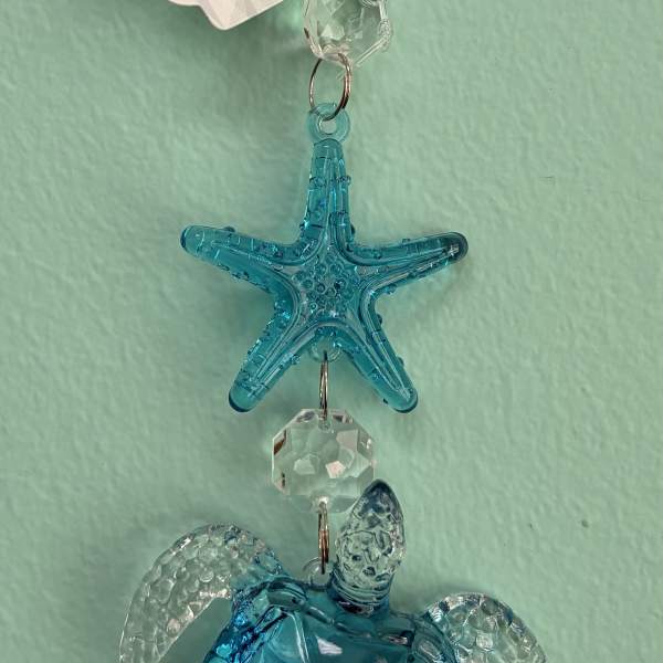 Blue crystal sea turtle and starfish hanging ornament with clear accents on a light aqua background