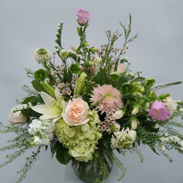 Mixed pastel flower arrangement in a glass vase