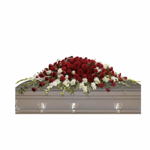 Red and white floral casket spray on a gray casket