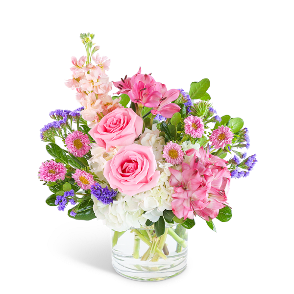 Short glass vase arrangement with pink roses, white hydrangeas, and mixed pink and purple flowers.