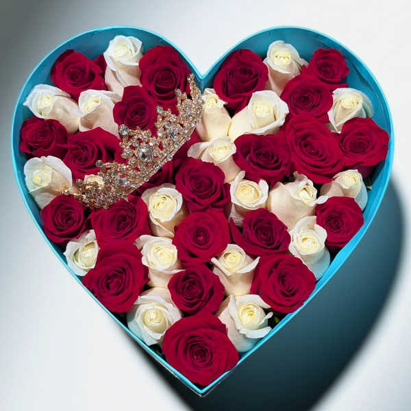 Heart-shaped turquoise box filled with red and white roses with a jeweled crown on top