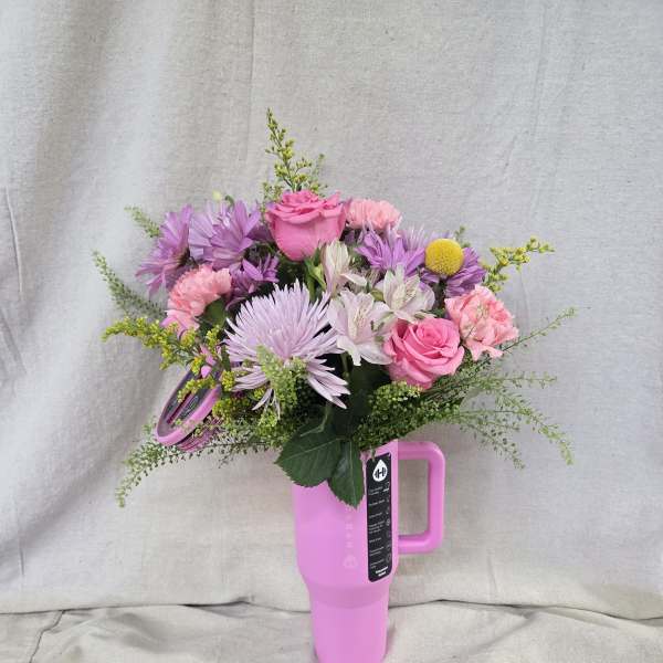 Pink and purple mixed bouquet arranged in a bright pink handled travel tumbler