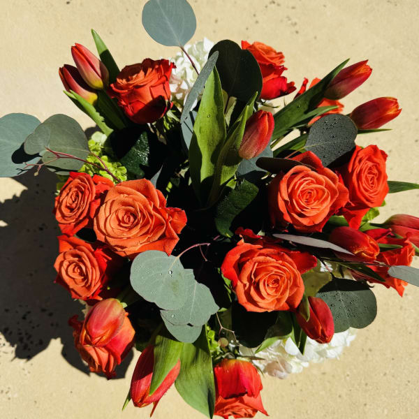 Bouquet of red roses and red tulips with eucalyptus leaves