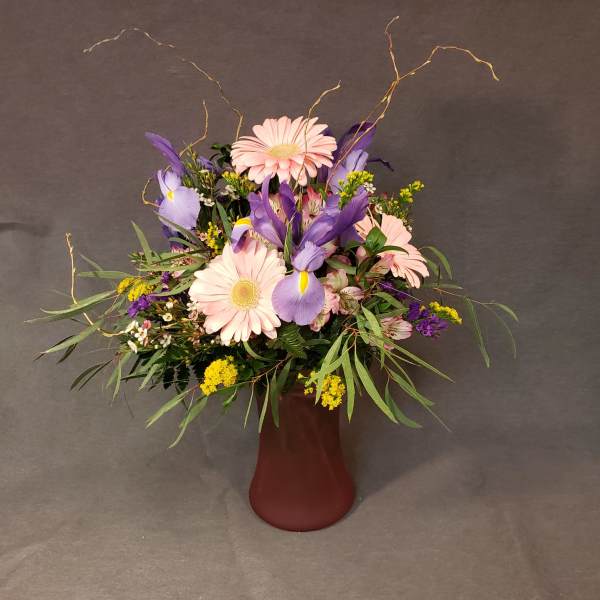 Pink and purple mixed bouquet in a burgundy vase