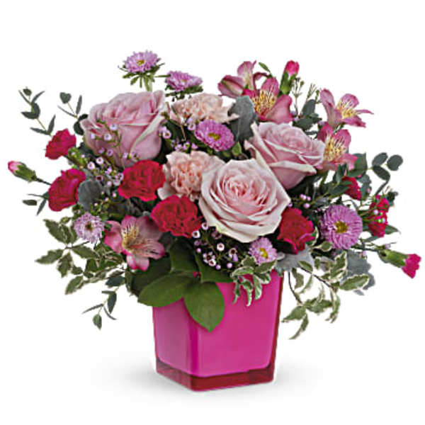Pink and red mixed flower arrangement in a magenta vase