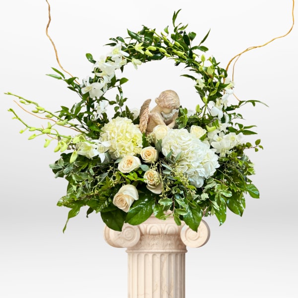 White floral arrangement with roses and hydrangeas on a pedestal