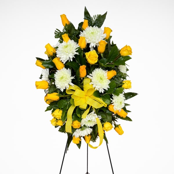 Yellow roses and white chrysanthemums on a standing easel with yellow ribbons