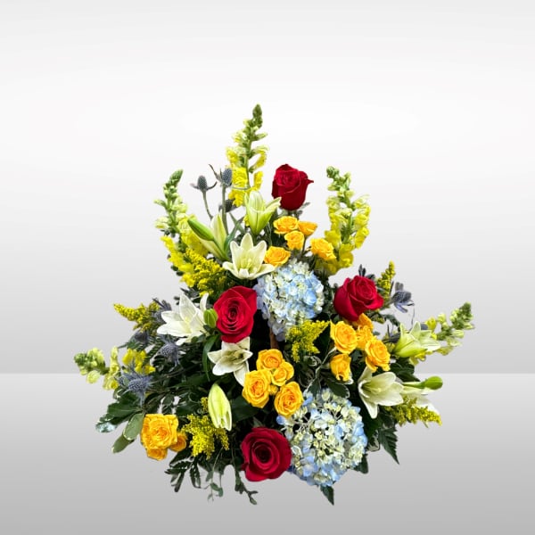 Mixed bouquet with red and yellow roses, lilies, and blue hydrangeas