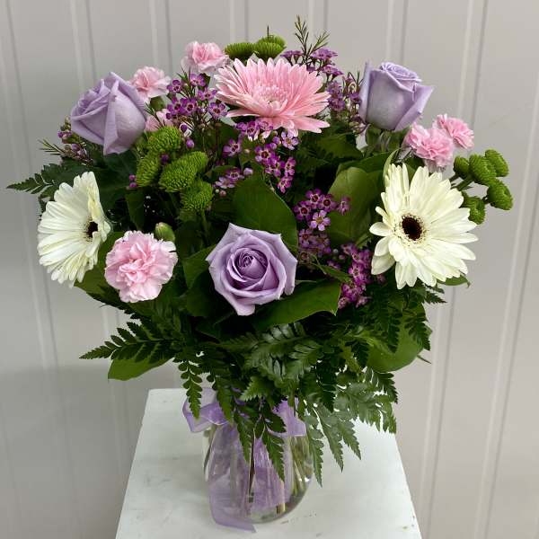 Bouquet of pink, lavender, and white flowers in a glass vase