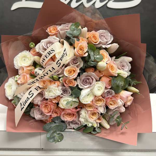 Bouquet of peach, blush, and white roses with eucalyptus
