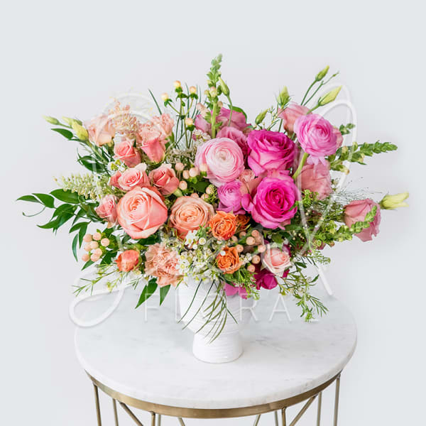 Pink and peach rose bouquet in a white vase