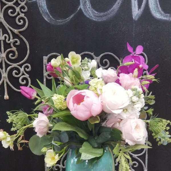 Pink and white floral arrangement in a turquoise vase