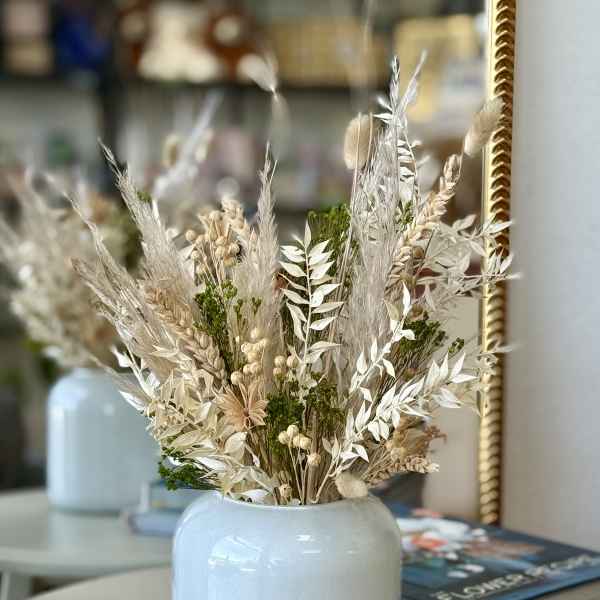 Dried floral arrangement in a pale blue vase