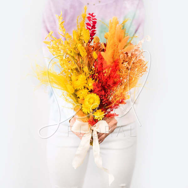 Bright bouquet of yellow, orange, and red dried flowers tied with a ribbon