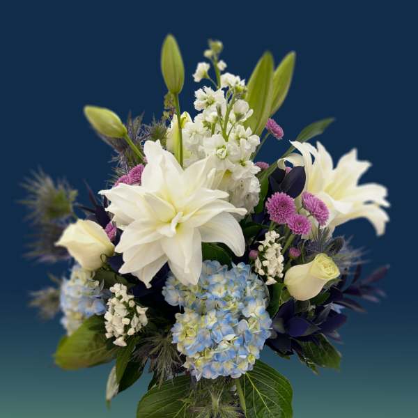 White lilies and blue hydrangeas in a blue vase