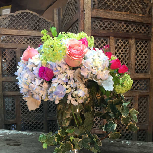 Mixed bouquet of roses and hydrangeas in a silver vase