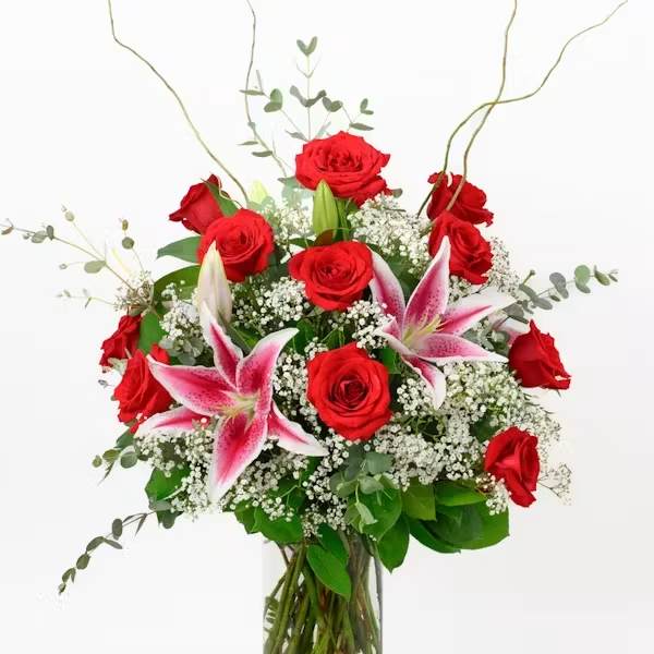 Red roses and pink lilies in a clear glass vase